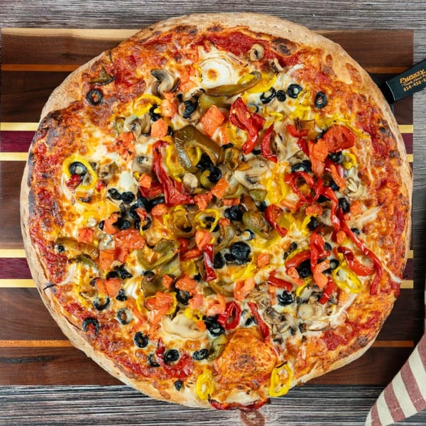 Punxsy Pizza's large, round pizza with diverse toppings, including olives, peppers, and mushrooms.
